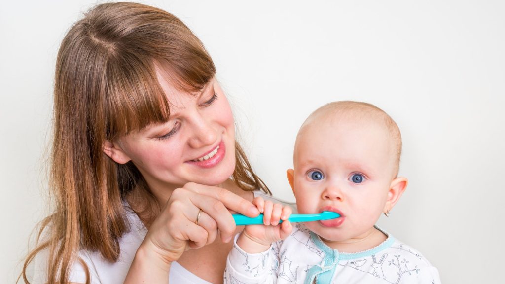 madre cepillando los dientes de su bebé