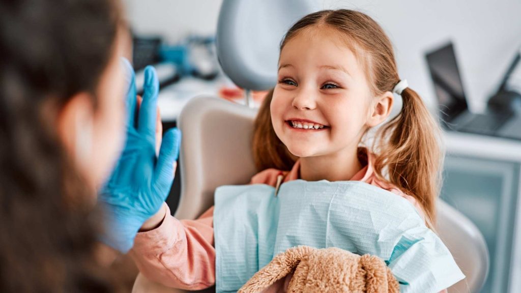 Niña sonriendo a una dentista